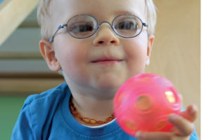 Frühförderkind mit Spielball