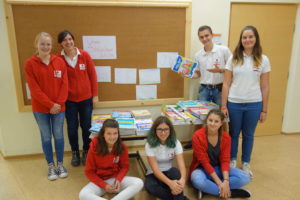 Jugendliche vom Roten Kreuz mit Schulbüchern zum Einbinden