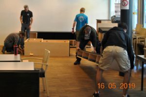 Die Schüler der TFBS Holztechnik, Absam, mit Fachlehrer Klaus Hechenblaickner bauen den Medienschrank im BSZ Tirol auf. Foto: BSVT/jandrasits