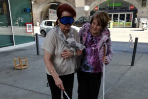 Frau mit Dunkelbrille und Begleitung