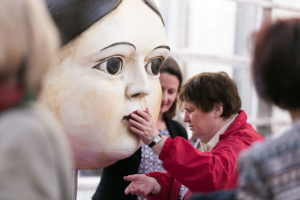 Blinde Besucherin betastet einen überlebensgroßen Puppenkopf