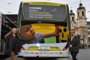 Sabine Karrer, Obfrau BSVT, und Maria Gandler, Leitung der Frühförderung des BSVT, stehen vor dem Bus mit BSVT Design 