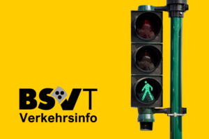 Eine Ampel zeigt grünes Licht für Fußgänger:innen. Daneben steht der Text 