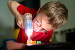Benedikt Betz beim Spielen mit Leuchtspielzeug, Foto: Julia Berger. 